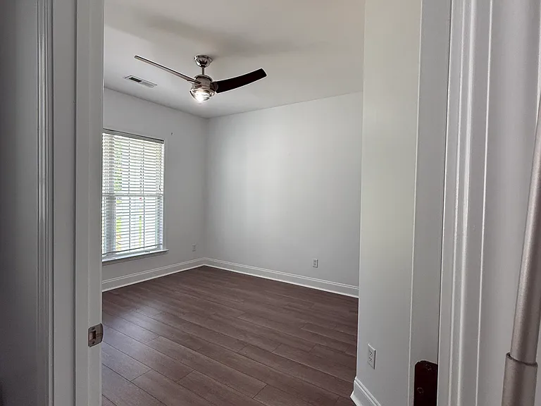Spacious main-level front bedroom with a clean, carpet-free layout, modern finishes, and neutral walls that work with any decor style."