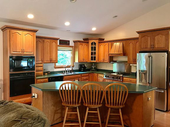 Oak kitchen with large center island. Refrigerator, microwa