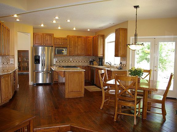Beautifully redone kitchen with slab granite counters and rich wood floors