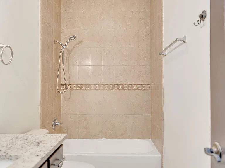 Bathroom interior at Merida Vista Apartments featuring a shower, toilet, and sink in Laredo, Texas