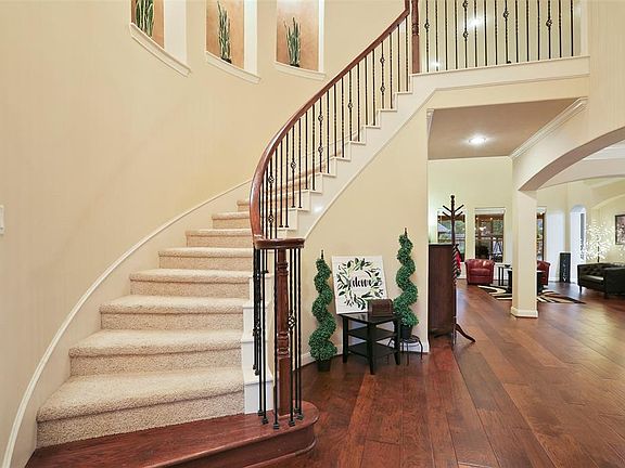 Open entry way with stunning hardwood flooring. Curved staircase with wrought iron spindles lined with three art niches to enjoy.