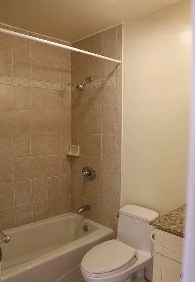 The bathroom is equipped with a Koehler bath tub, Toto one-piece toilet, vanity sink with granite countertop.