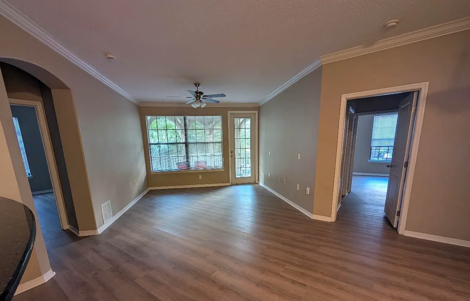 A living room with entries to both bedrooms