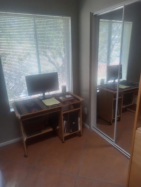 desk and closet in furnished bedroom