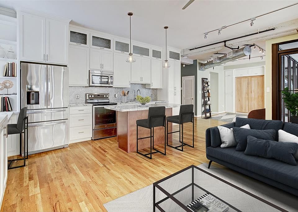 This spacious corner unit, virtually staged, gives you an idea of how welcoming the whole space can be! See the murphy bed behind the stained door to 