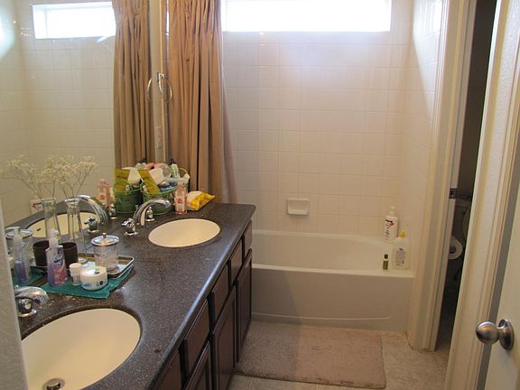 Master bath with double sink and toilet with privacy door