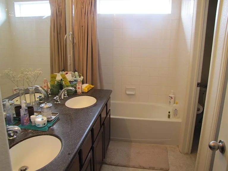 Master bath with double sink and toilet with privacy door
