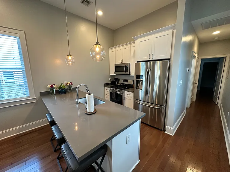 Kitchen (different viewpoint). Also, a view of the hallway leading to bathroom (first door on the left), washer/dryer (second door on the left), attic storage space, and bedroom (door at the end of the hallway). Nest thermostat.