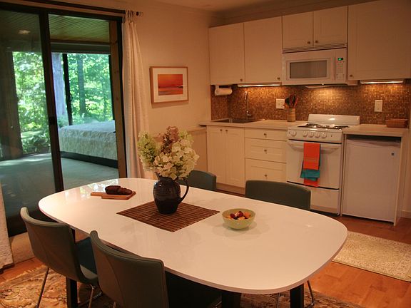 Photo of eat in kitchen and work area. The apartment is furnished. A standup refrigerator with freezer in the garage provides extra food storage.