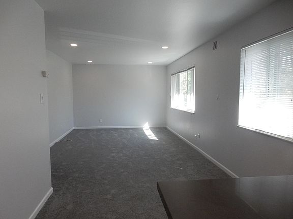 Living room adjoins kitchen. Both rooms face trees on Central Ave. Dimmable recessed lighting