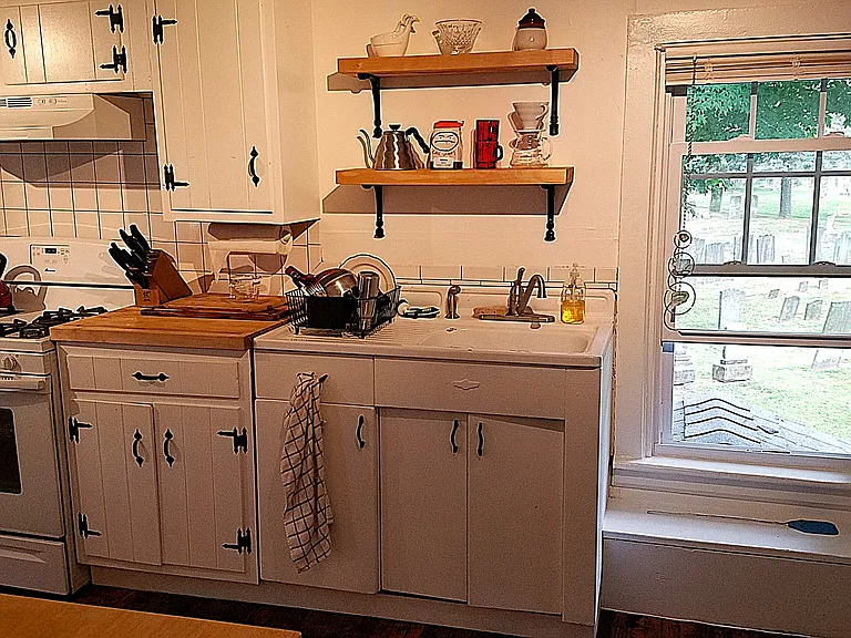 Butcherblock countertops, original vintage sink and real wood cabinets in the charming kitchen. Views of the cemetery. Quiet neighbors!