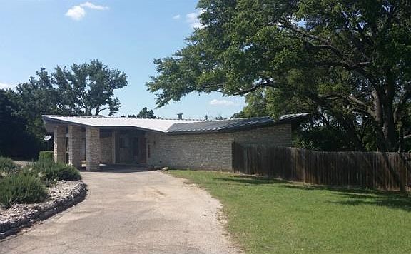 Additional photo of front exterior, surrounded by trees