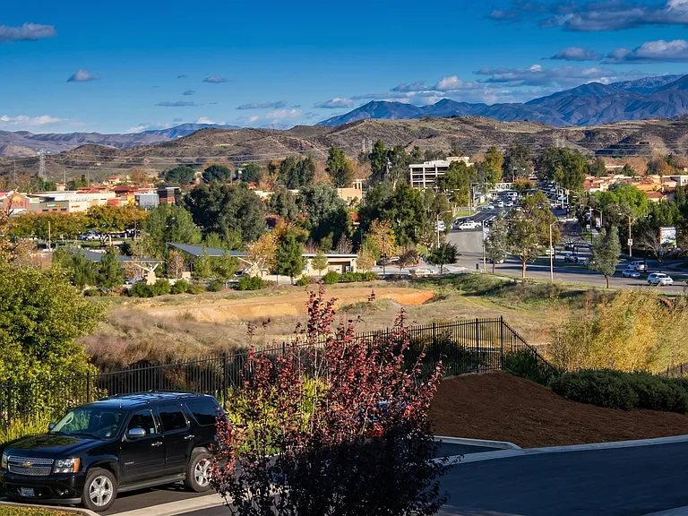 Panoramic view from master bedroom balcony overlooking Valencia Town Center and Magic Mountain Parkway with surrounding hills