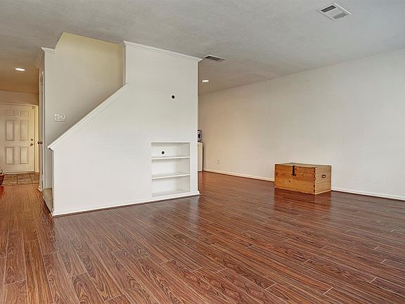 Step into this inviting from the patio and youâll know youâre home. Notice the beautiful laminate wood floors, built-in shelving, recessed lighting and decorative base molding and crown molding around the stairs. In this photo you can see the sta