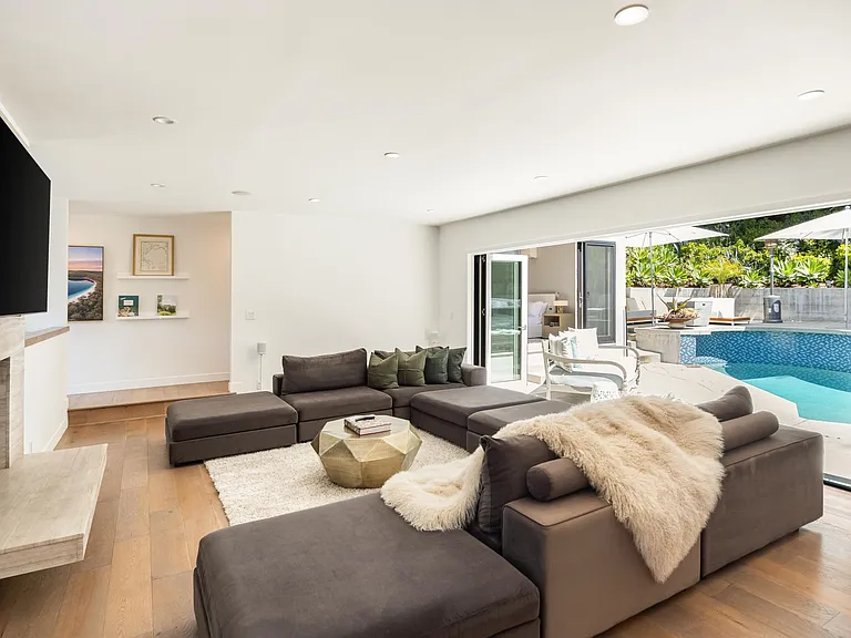 From the living area's sofa, catch your favorite shows on TV with direct access to the pool just steps away.
