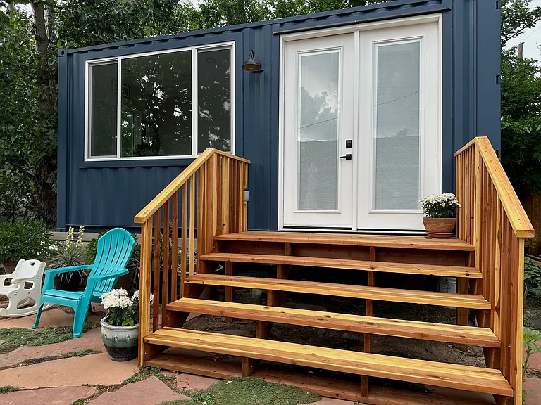 Private office custom-built from an upcycled shipping container, featuring cedar stairs and a spacious entry deck