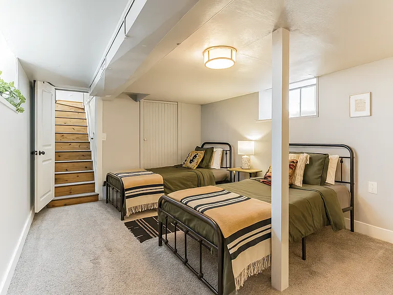 Settle in downstairs with two twin beds, soft lighting, and thoughtful decor for a comfortable stay.