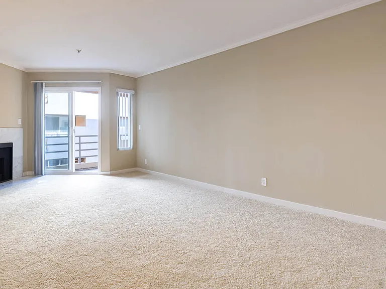 Carpeted Living Room with Fireplace and Balcony