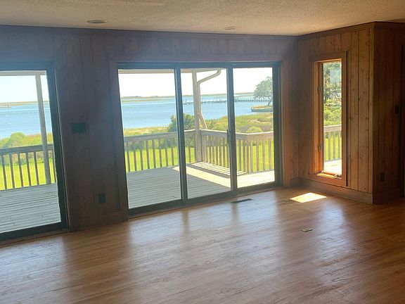 Beautiful Open Living/Dining area with water view and dock in the backyard.