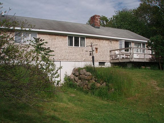 Back yard with tipsy birdfeeder