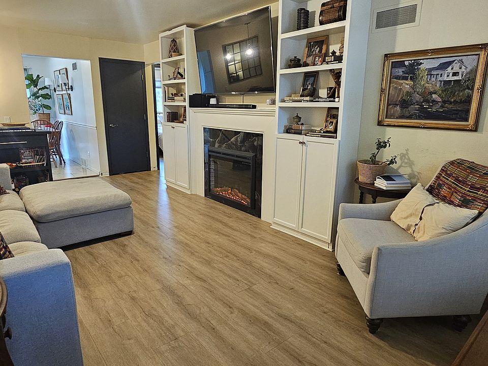 Enter into the living room, with electric fireplace and surrounding built-ins (they are permanent installations and will be staying).