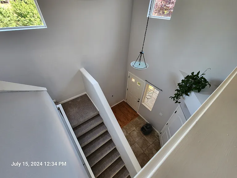 From the top of the stairs looking down to front door and garage door
