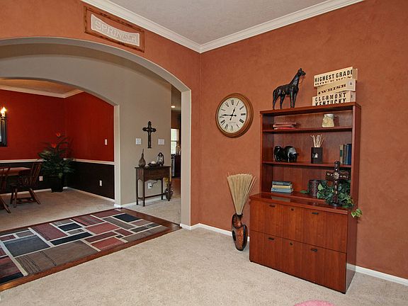 Large formal LR/study with crown molding, arched opening to foyer & faux paint