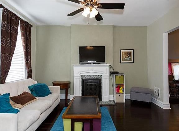 Beautiful wood floors, tall ceilings and antique ornamental fireplace. Large doorway to dining room