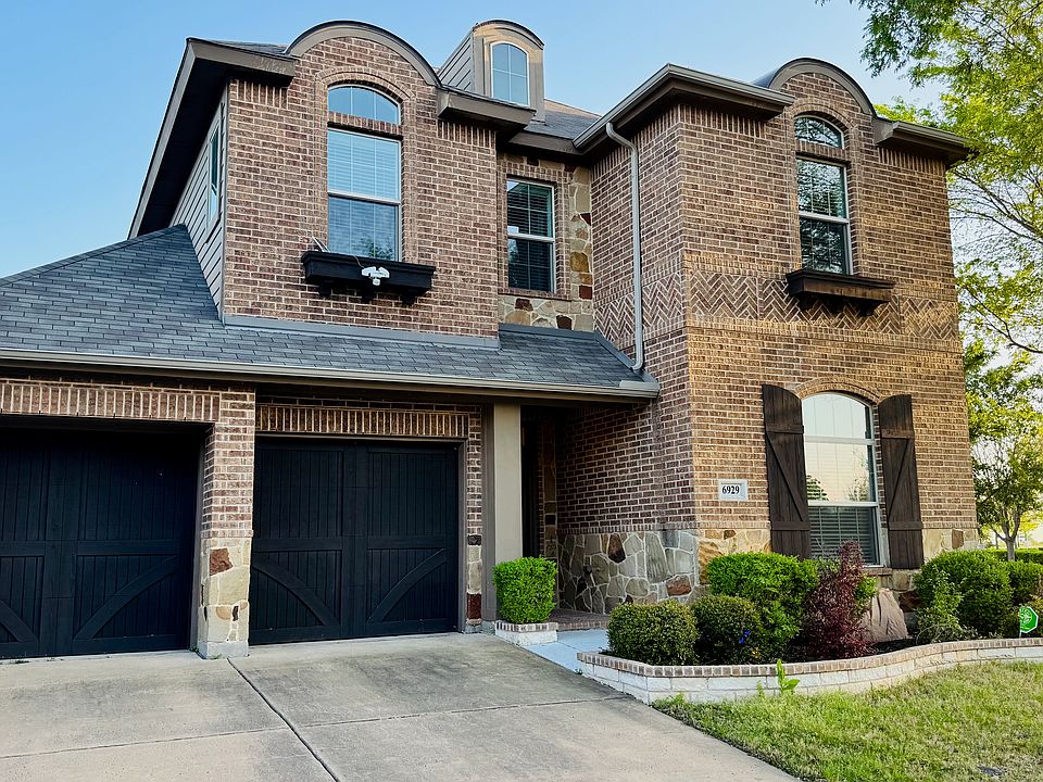 View of front facade with a garage, brick siding, and driveway
