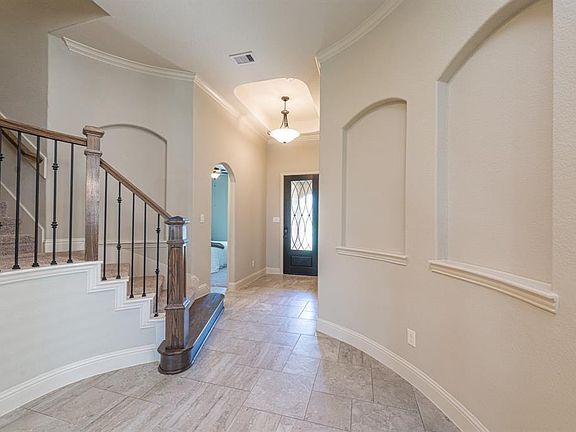 Off-set tile floors welcome you into this pristine home which features graceful architectural lines throughout.