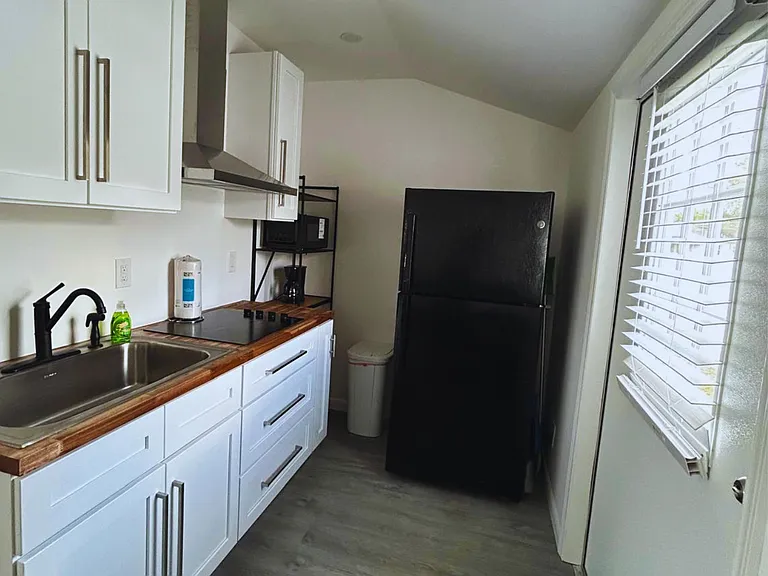 Kitchen stocked with a fridge, microwave, soap & paper towels