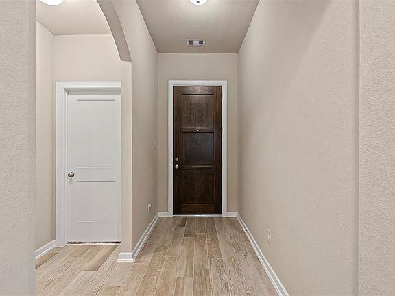 The rich brown door color contrasts beautifully with the wood look tile flooring which flows throughout the living spaces of the home.