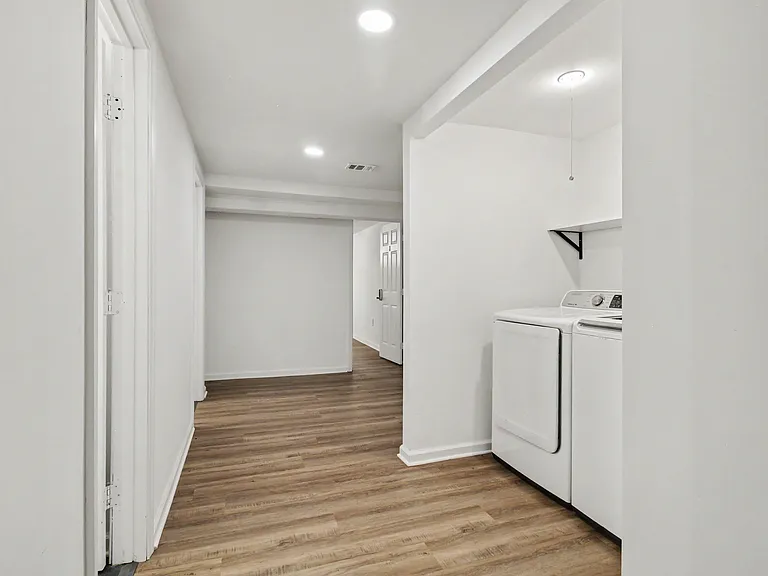 Convenient laundry nook with in-home washer and dryer, plus durable flooring and easy access to the main hallway.