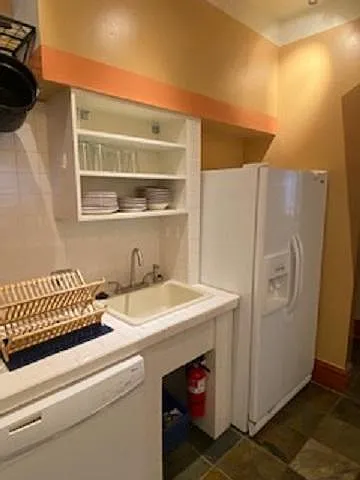 Kitchen area with dishwasher and full size refrigerator