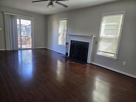 Living room with door to rear deck overlooking fenced-in backyard.