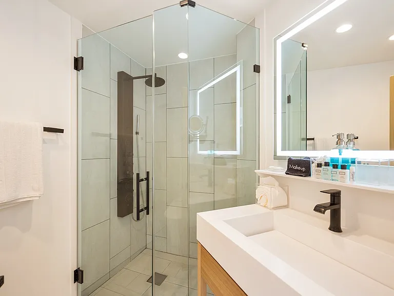 Clean and crisp bathroom with fresh towels and LED-lit vanity mirror.