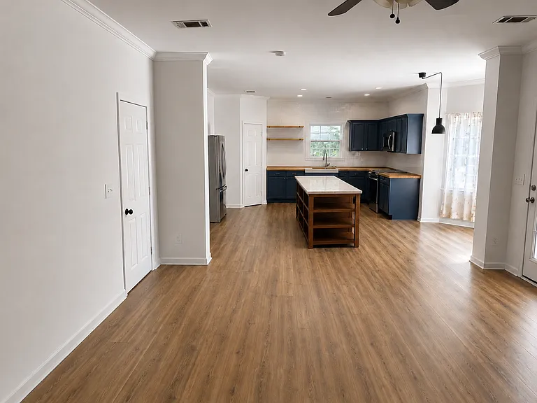 Open-concept kitchen and living area with continuous flooring and natural light