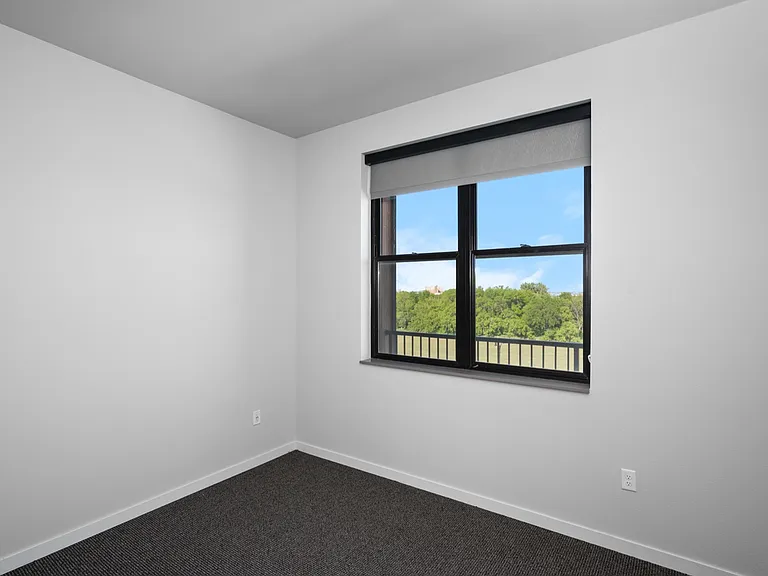 Bright and inviting room with a large window showcasing a scenic green view, promising natural light and tranquility. Bright and inviting room with a large window showcasing a scenic green view, promising natural light and tranquility.