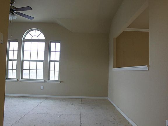Upstairs game room with large window and opening on right looking down into entryway.  Carpet's not in yet.