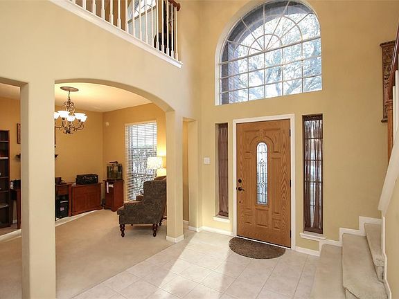 Grand entry with high ceilings, elegant arched window and designer front door with leaded glass.