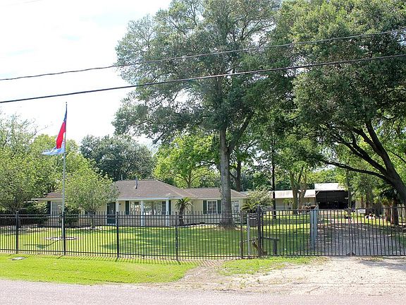 This gated driveway on the side of the home leads back to the 3 garage bay shop in the back and has a fence that separates the large backyard. This would be perfect for your livestock or home based business.