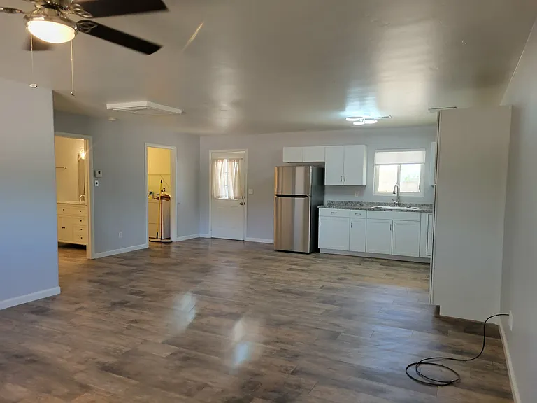 From the Family Room, this image shows the kitchen, the front door entry, the door into laundry room and door into bathroom