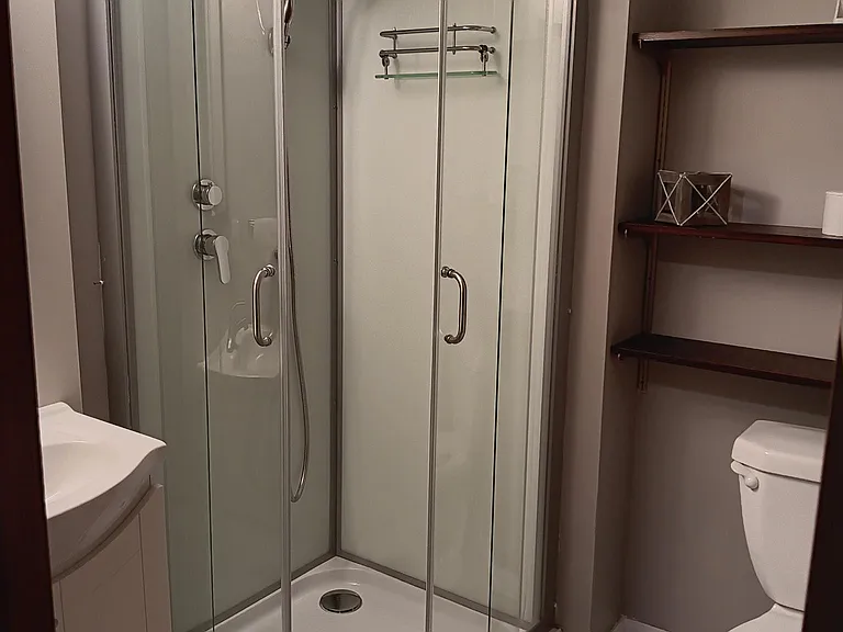 Downstairs bathroom with tile flooring and shelving.