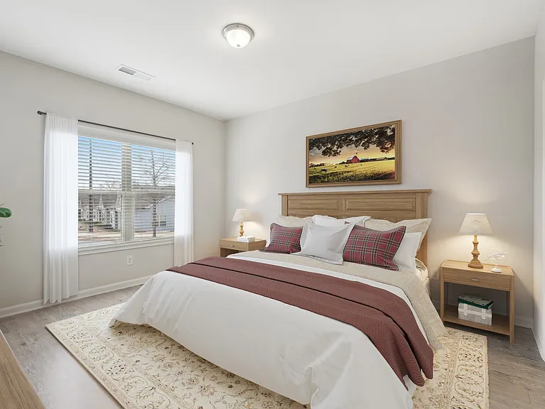 Primary bedroom with king size bed and large window.