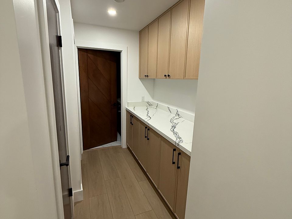 Hallway to 2nd bedroom and bathroom; additional storage cabinets and counter
