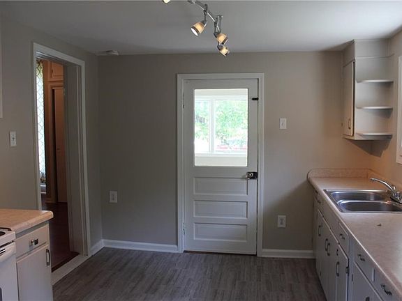Kitchen looking toward back door leading to enclosed back porch.