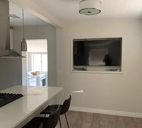 Here it is! The big screen smart TV you can adjust for viewing from kitchen, dining room and living room. You get a peek at the laundry room beyond the kitchen.