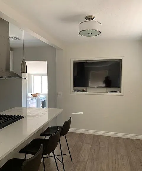 Here it is! The big screen smart TV you can adjust for viewing from kitchen, dining room and living room. You get a peek at the laundry room beyond the kitchen.