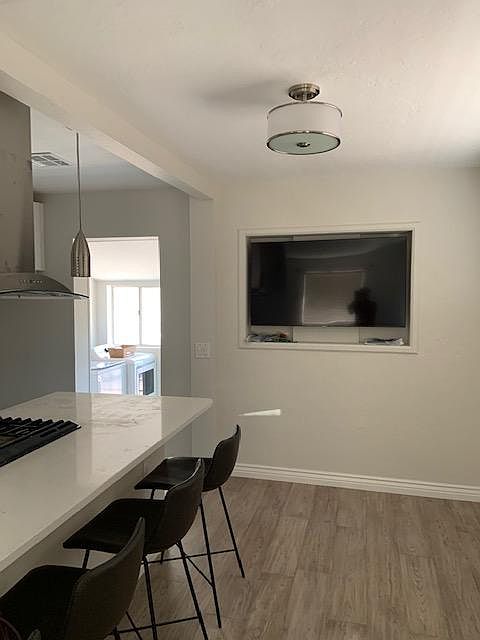 Here it is! The big screen smart TV you can adjust for viewing from kitchen, dining room and living room. You get a peek at the laundry room beyond the kitchen.