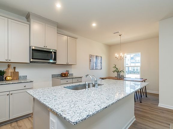 The sprawling kitchen island overlooks the open-concept dining and great rooms.